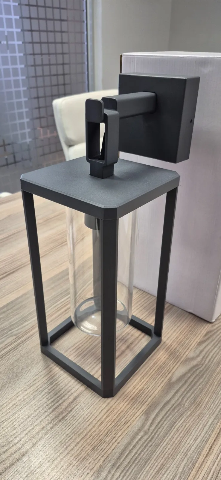 A phone photo of an outdoor wall lantern standing on a desk